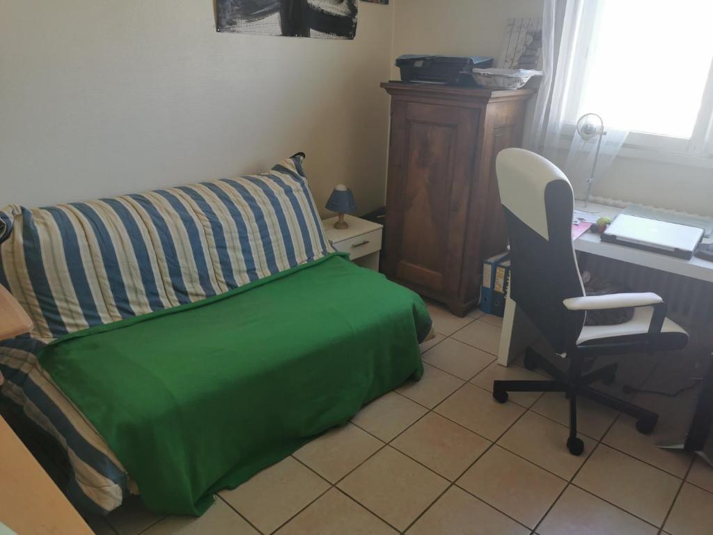 Schlafzimmer mit einem Bett, einem Schreibtisch und einem Stuhl in der Unterkunft Chambre in Ville-la-Grand