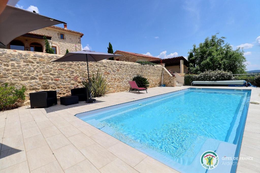 une piscine devant une maison dans l'établissement Le Bonlieu des Volets rouges, à Saint-Sauveur-de-Cruzières