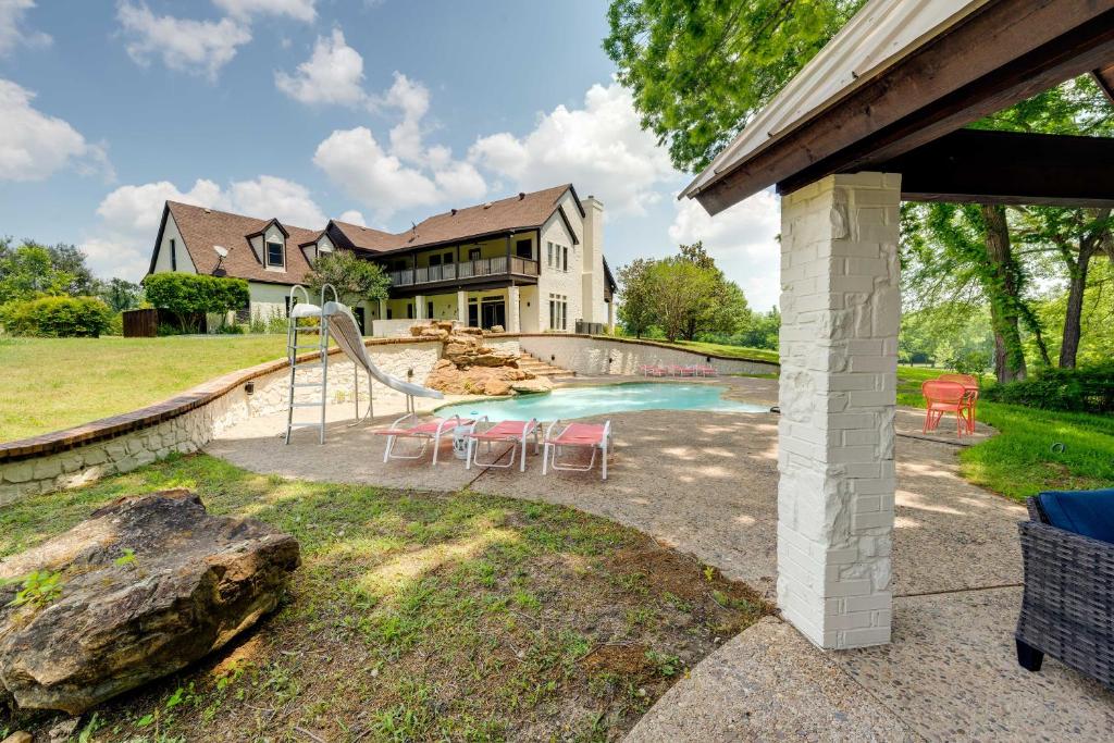 een huis met een zwembad met een glijbaan bij Luxury Texas Villa on 10 Acres with Pool and Pond! in McKinney