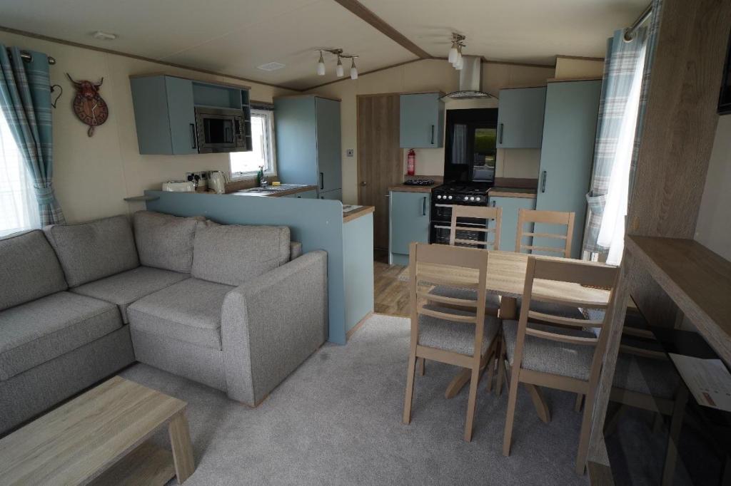 a living room and kitchen with a couch and a table at Heacham Sunset lodge Platinum van in Hunstanton