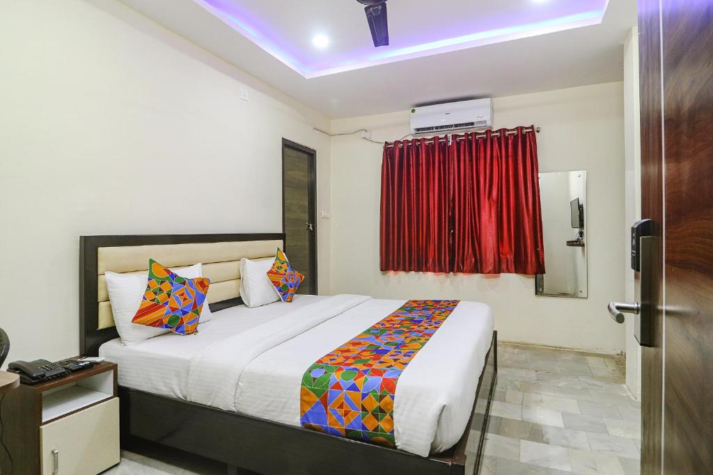 um quarto com uma cama grande e uma janela vermelha em FabHotel Lotus Park em Visakhapatnam