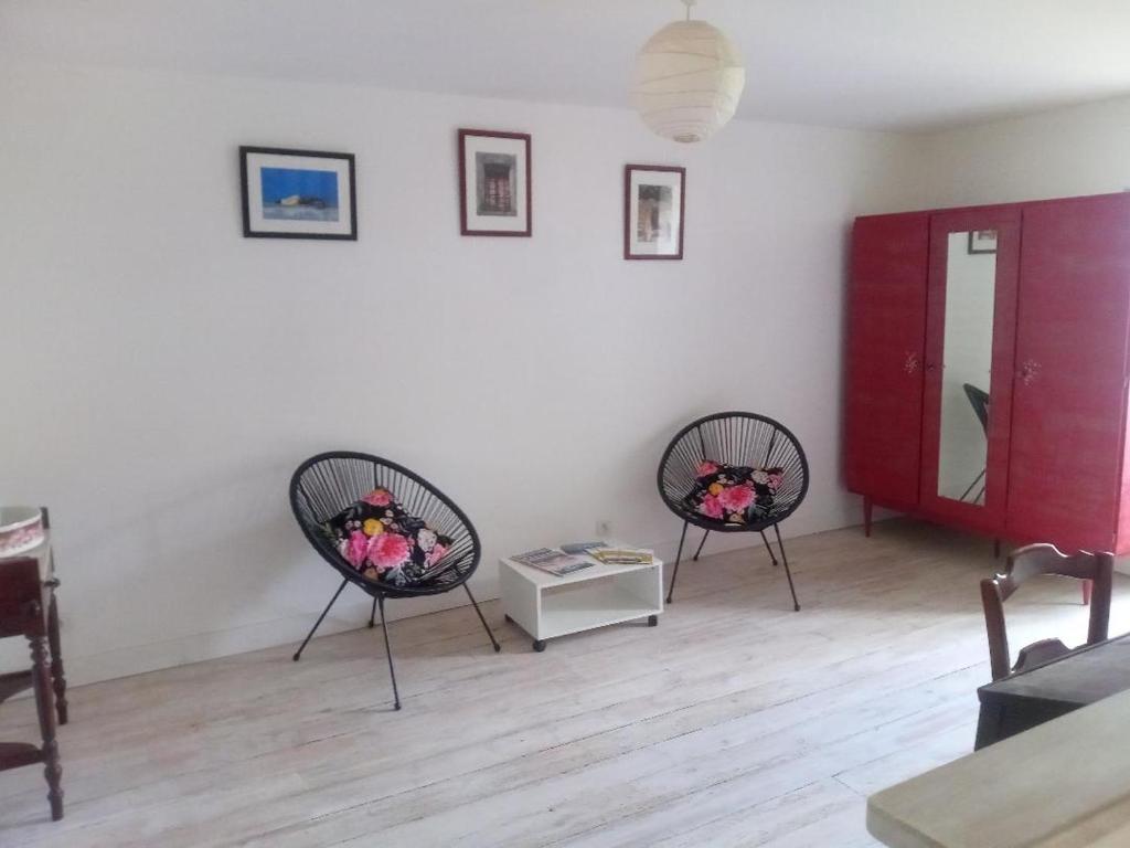 ein Wohnzimmer mit 2 Stühlen und einem Tisch in der Unterkunft chez Florence, chambres d'hôtes , Montrol Sénard 