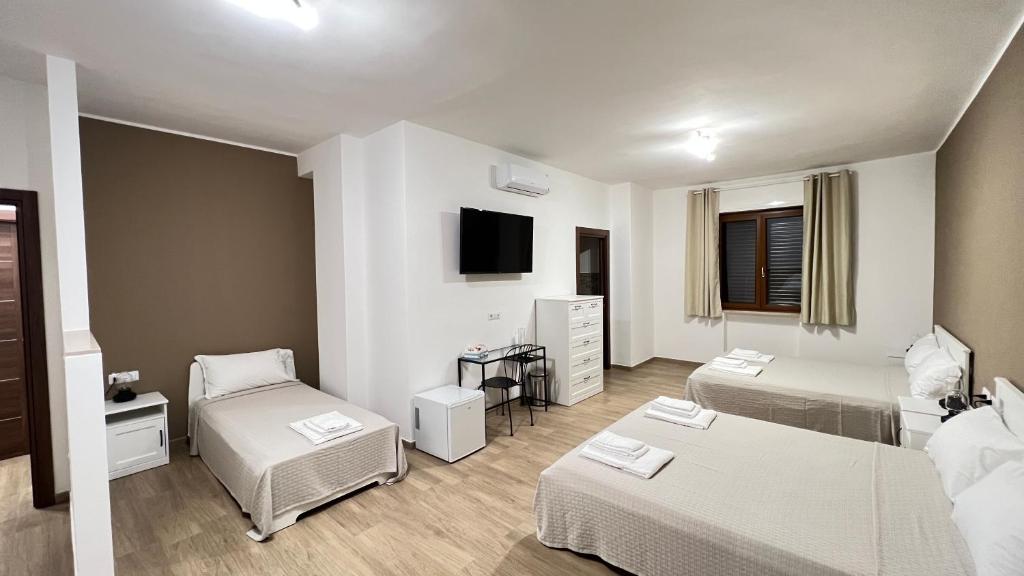 ein Wohnzimmer mit 2 Betten und einem TV in der Unterkunft Cala Portavecchia in Monopoli