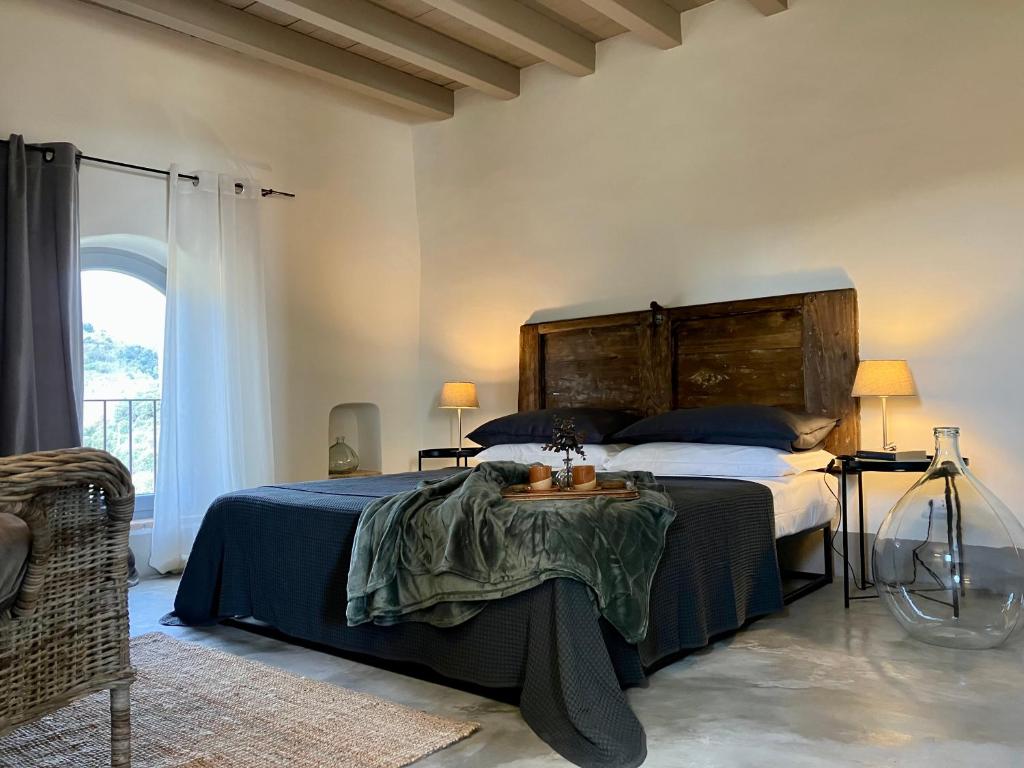 a bedroom with a large bed with a wooden headboard at Il Contado in Noli