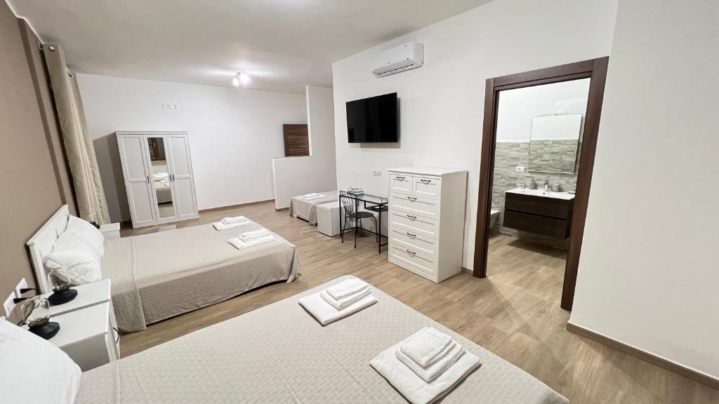 a bedroom with two beds and a sink and a mirror at Cala Portavecchia in Monopoli