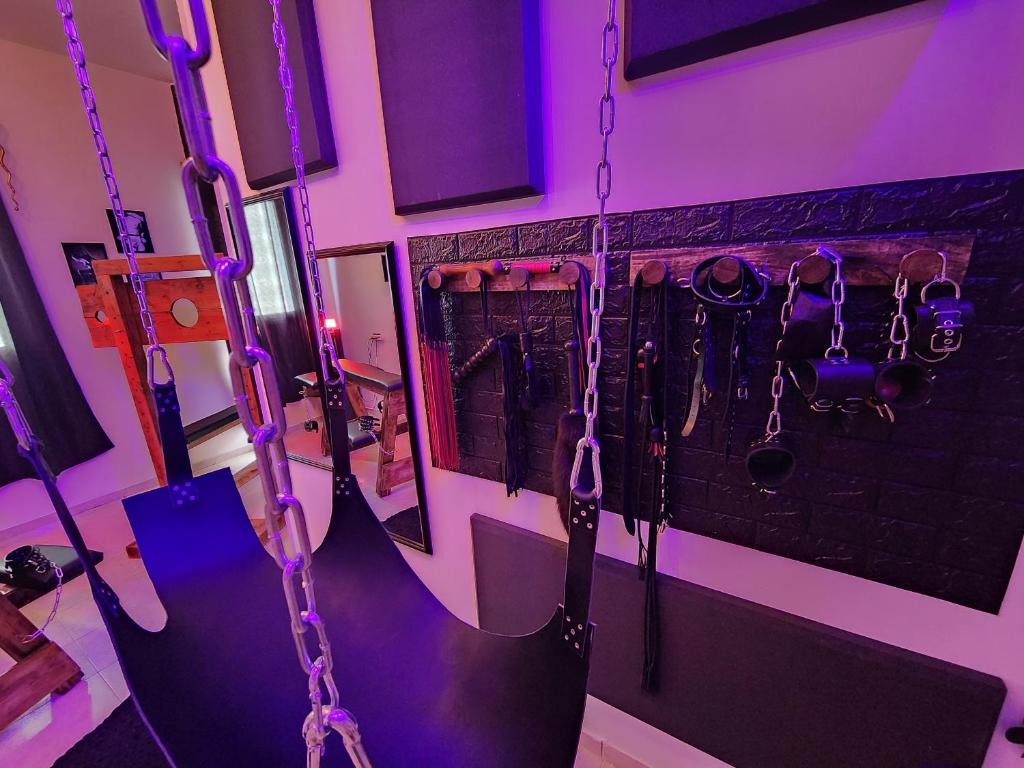 una habitación con un grupo de cadenas colgando de una pared en Taboo21+ en Ashkelon