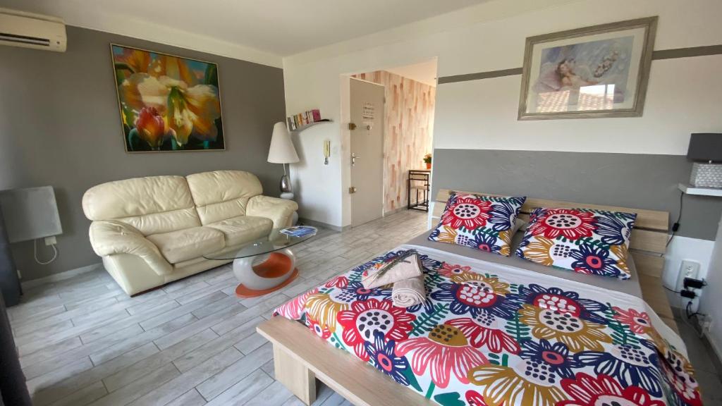 een woonkamer met een bed en een bank bij Le Goeland 3 ,balcon petite vue mer latérale au 3 eme étage sans ascenseur in Toulon