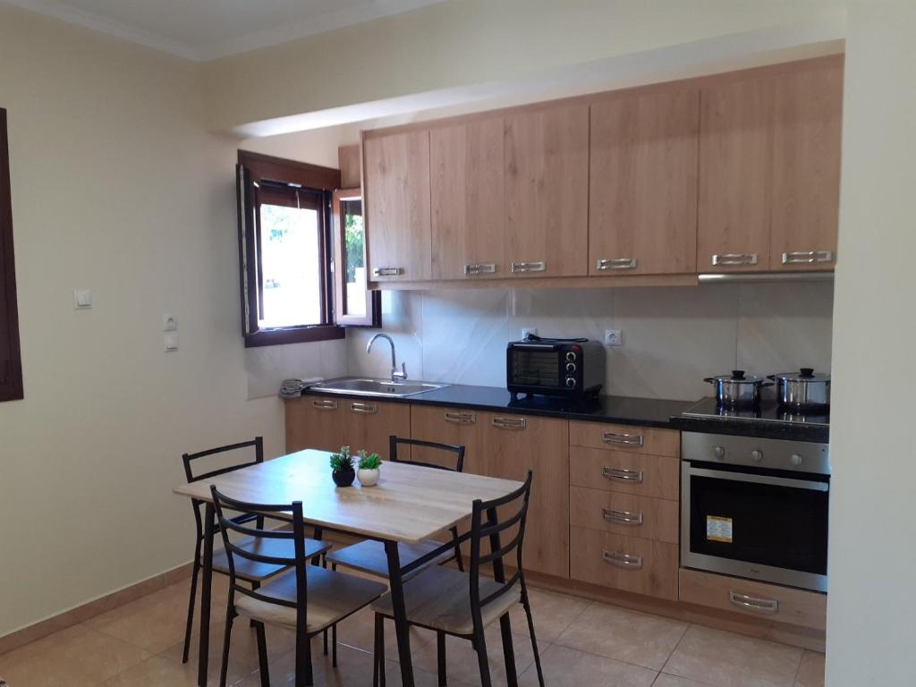 a kitchen with wooden cabinets and a table and chairs at Maria's home - Katelios in Katelios