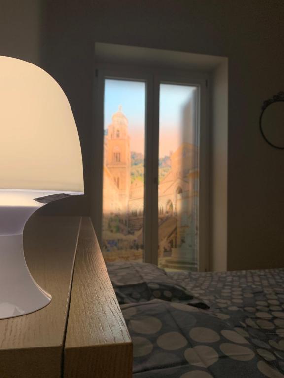 een slaapkamer met een raam met uitzicht op een gebouw bij Vesuvio House in Boscoreale