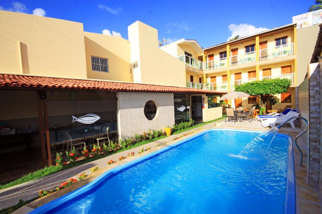 uma piscina em frente a um hotel em Pousada Badejo em Japaratinga