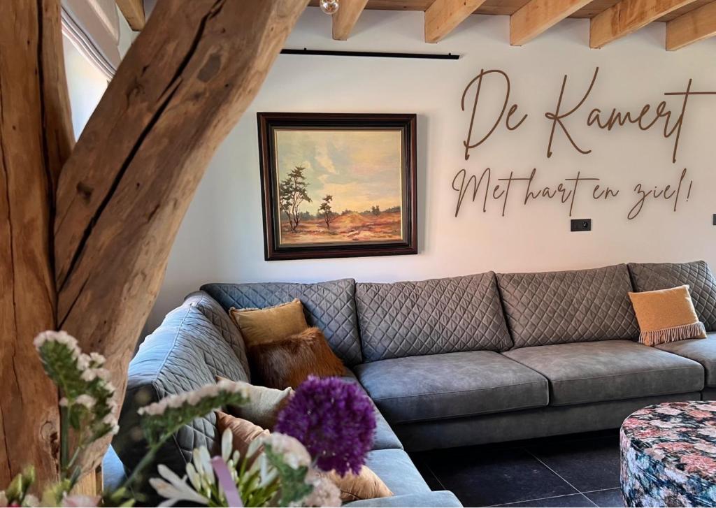 una sala de estar con sofá y una pintura en la pared en De Kamert en Hechtel-Eksel