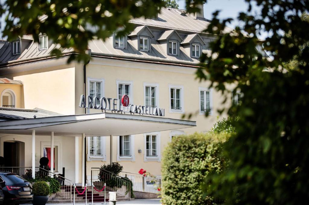 a large white building with a sign on it at ARCOTEL Castellani Salzburg in Salzburg