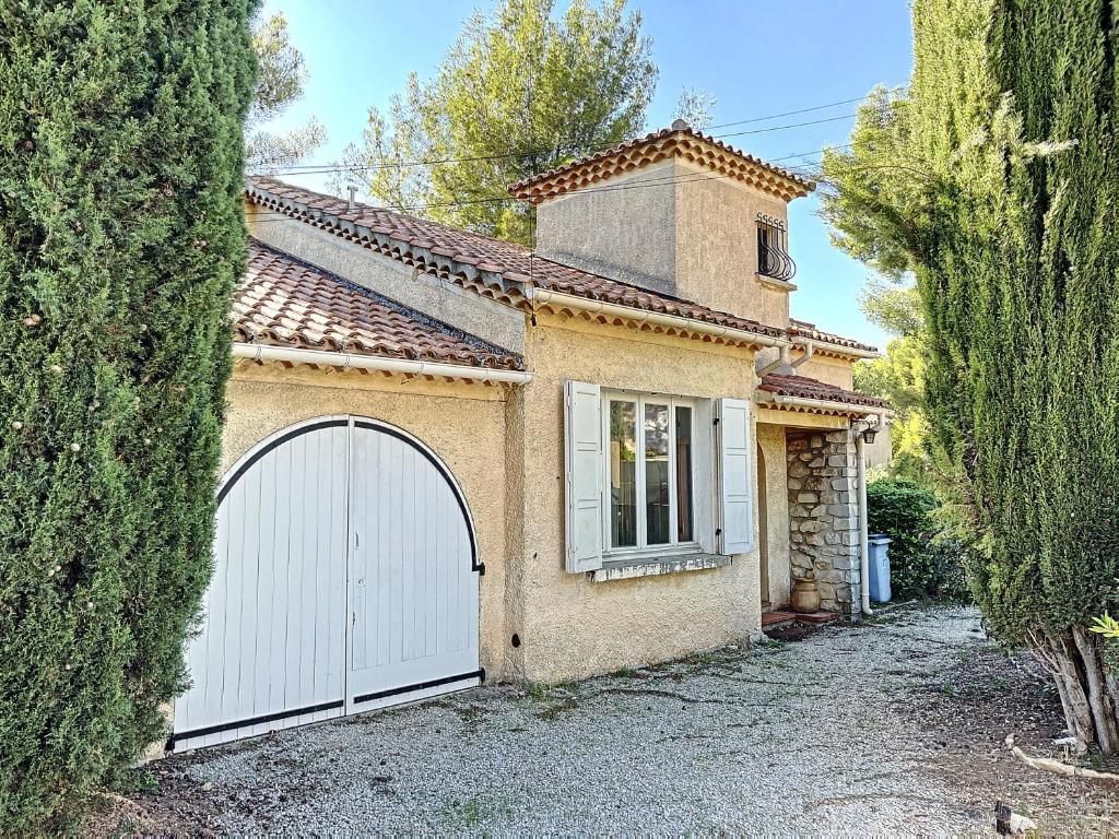 a house with a white garage door in a yard at CAPELAN in Bandol