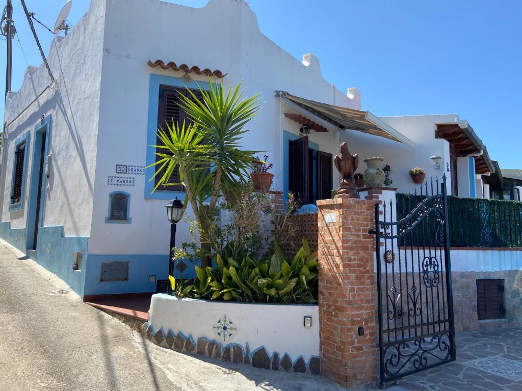 een wit huis met een poort met een bos planten bij Casa Culia - Holiday Housing in Lipari