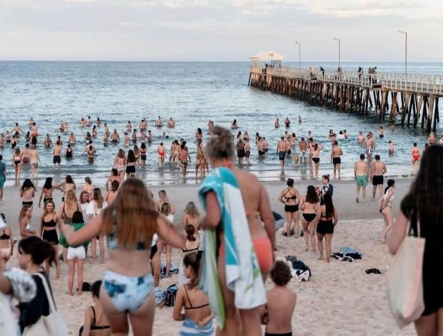 una multitud de personas en una playa con un muelle en The Sea Haven 200m to Henley Beach, en Henley Beach South