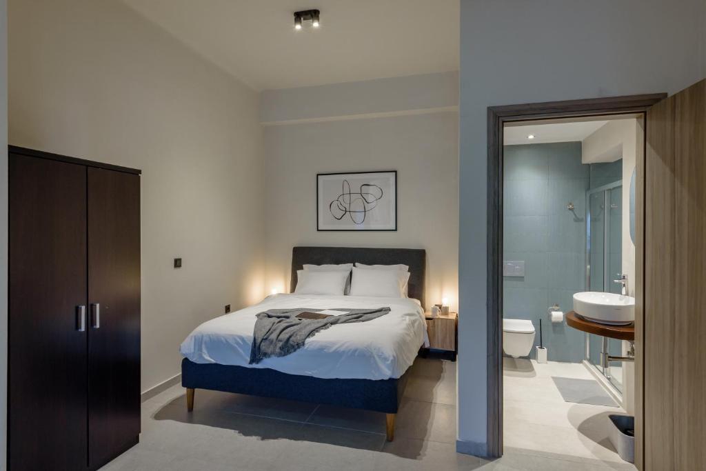 a bedroom with a bed and a bathroom with a sink at Galio Suites Airport by Airstay in Spata