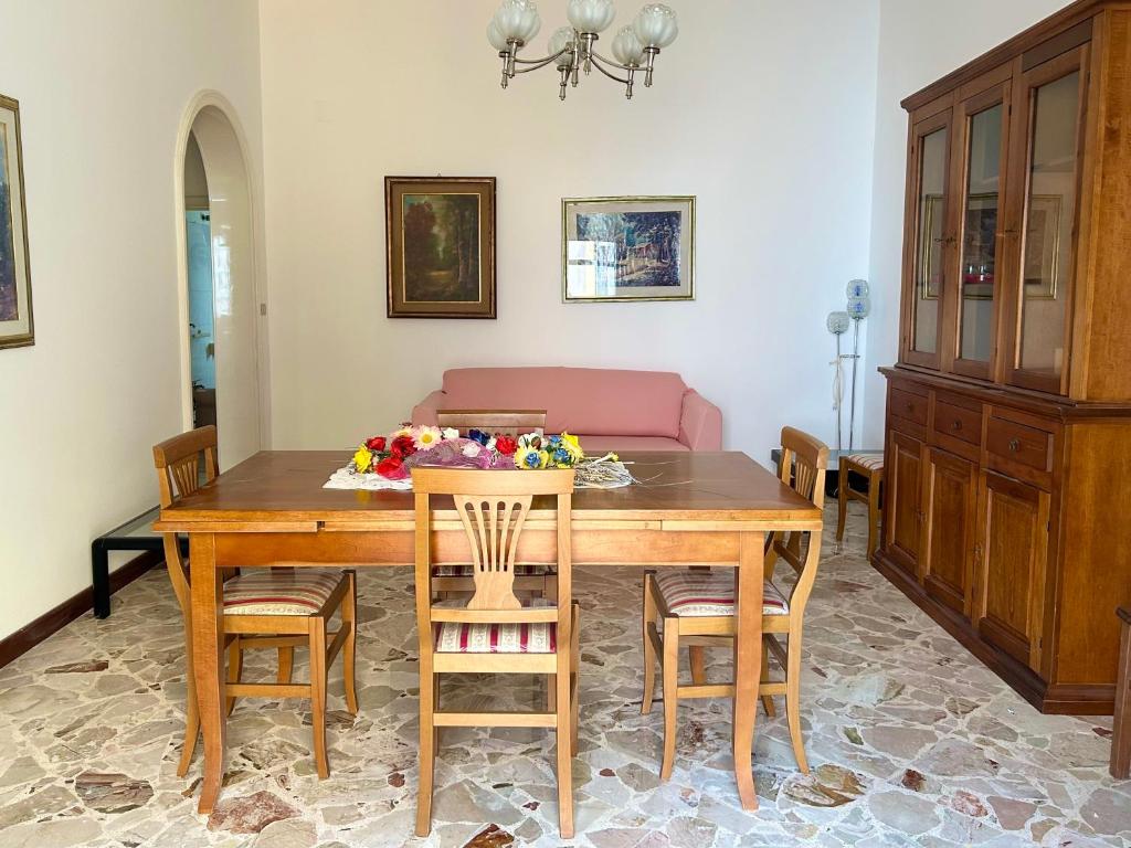 comedor con mesa de madera y sillas en Appartamento - Morciano Di Leuca, en Morciano di Leuca