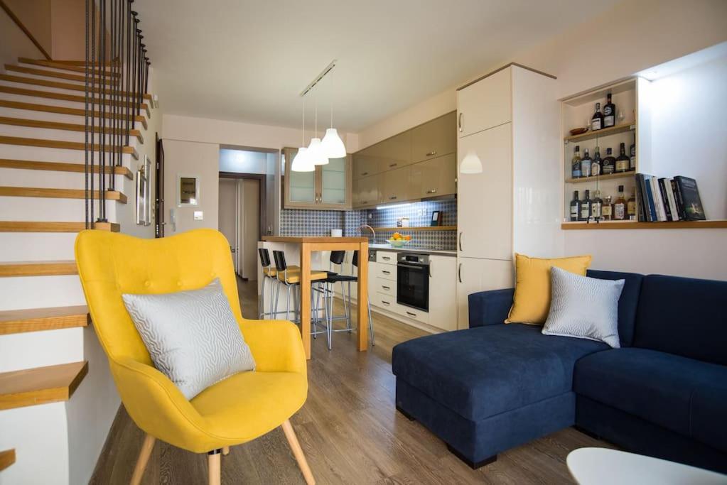 a living room with a blue couch and a yellow chair at Modern, Stylish Maisonette in Itea