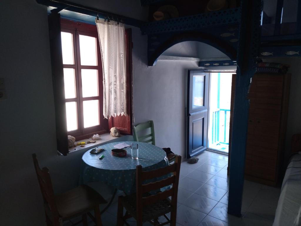 a dining room with a table and two windows at KARAI in Astypalaia Town