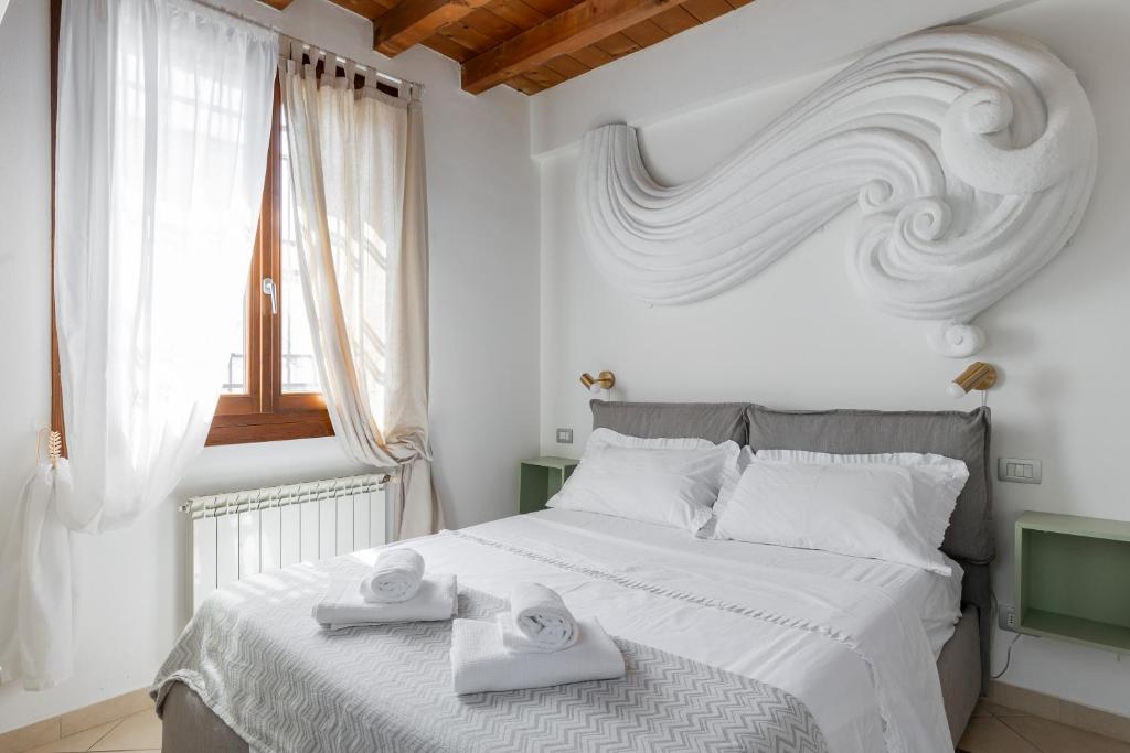 ein Schlafzimmer mit einem weißen Bett mit zwei Handtüchern darauf in der Unterkunft Osvaldo - parcheggio e giardino privato in San Giovanni in Persiceto