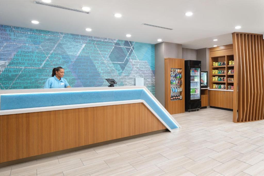 a woman is standing behind a counter in a hospital lobby at SpringHill Suites by Marriott Jacksonville Baymeadows in Jacksonville