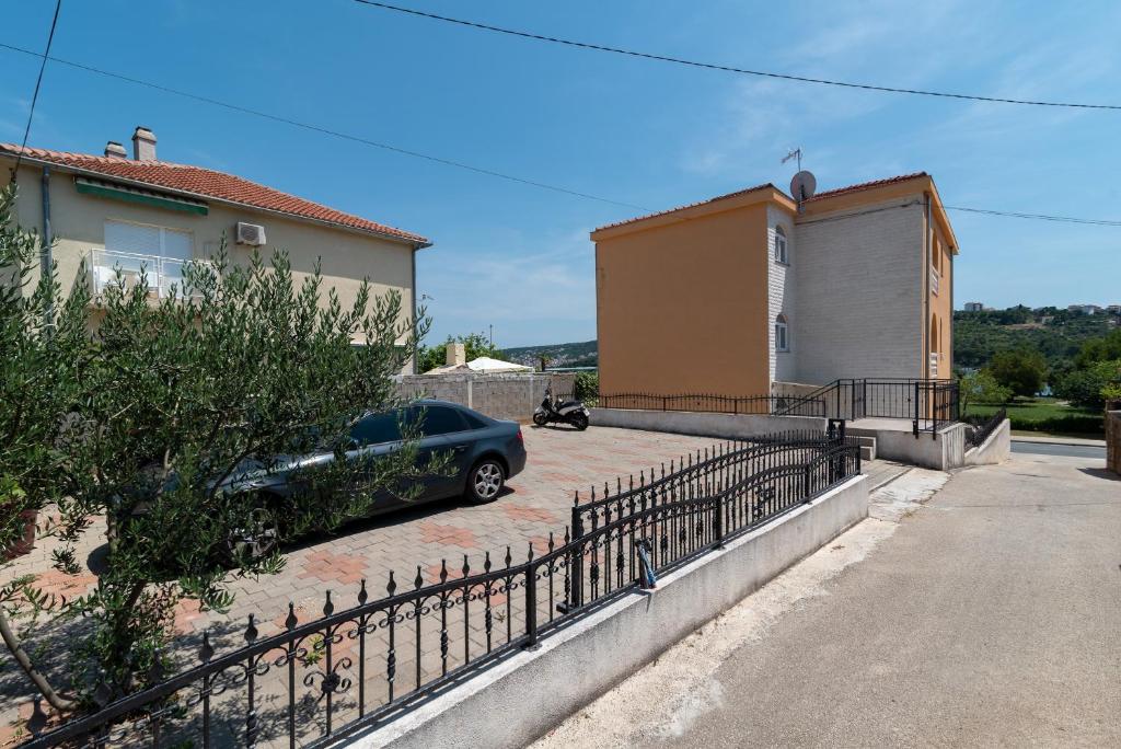 un coche aparcado en una entrada junto a una casa en A3 - seafront apt with balcony 1 min to beach en Trogir