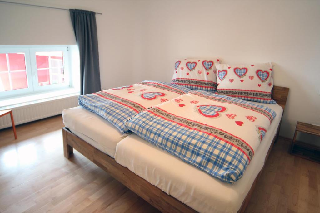 a bed with a comforter and pillows on it at Gala Apartments - Country Oasis in Pettenbach in Pettenbach