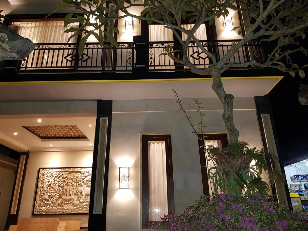 a hotel lobby with a balcony and a tree at Villager's House Ubud in Gianyar