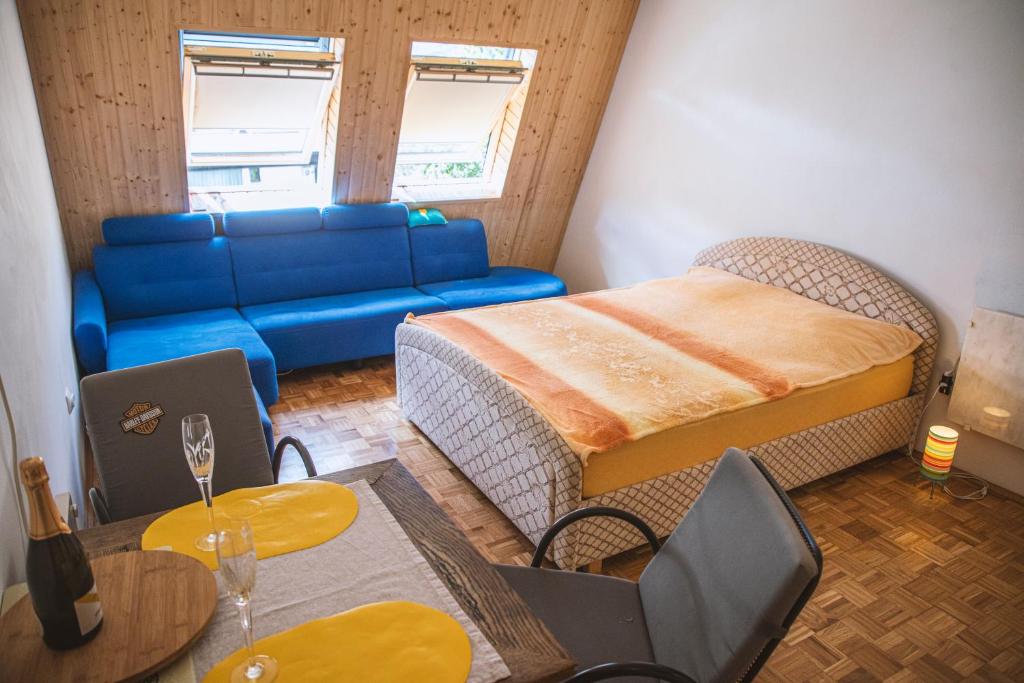 Sala de estar con sofá, cama y mesa en Sončni apartma en Bovec