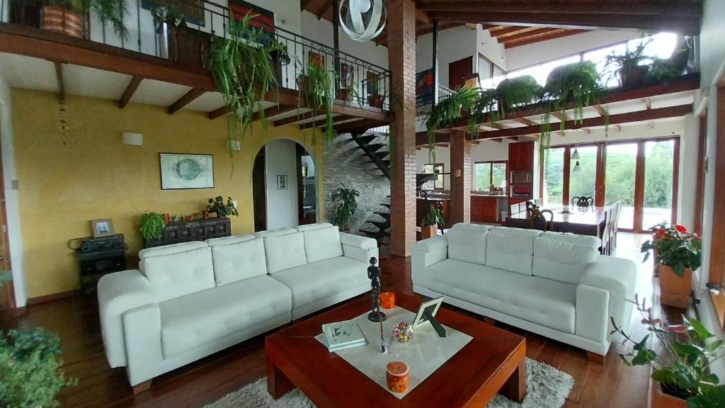 a living room with two white couches and a table at Villa campestre casa blanca in San Pedro