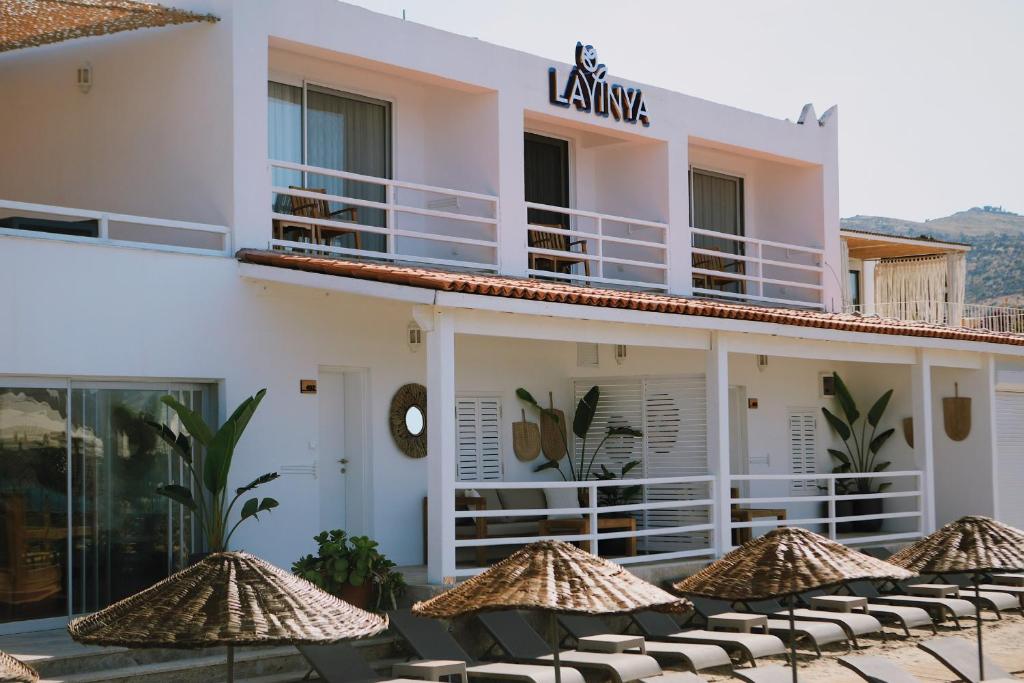 a hotel with chairs and umbrellas in front of it at Lavinya Otel in Golturkbuku