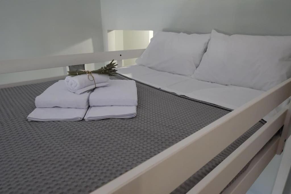 Una cama con toallas encima. en Δ1 - Τα διαμερίσματα του δασκάλου στα Φιλιατρά, en Filiatra