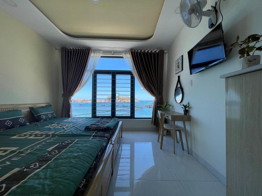 Ánh Dương في كوي نون: غرفة نوم مع سرير وإطلالة على المحيط