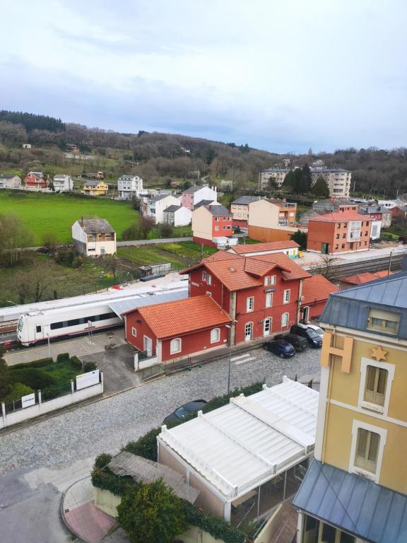 une vue sur une ville avec un train passant par dans l'établissement López Estación, à Sarria