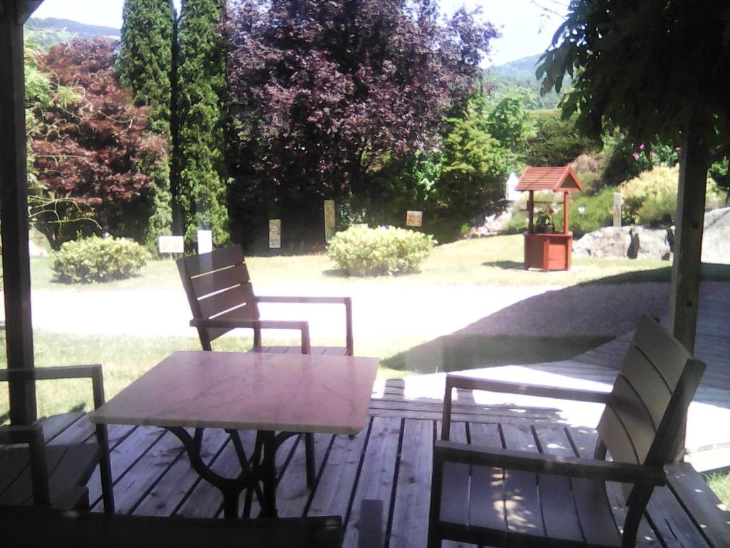 a table and two chairs on a wooden deck at Chalet de Grettery in Saulxures-sur-Moselotte