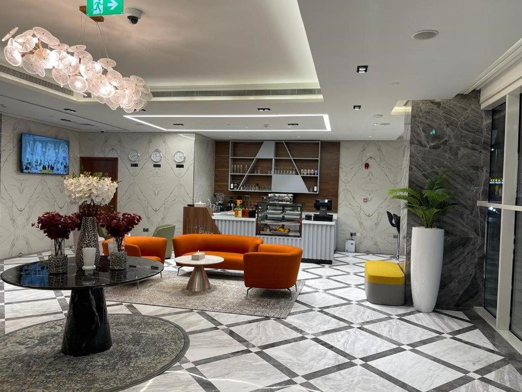 a living room with orange chairs and a table at BANIYAS PLAZA HOTEL APARTMENTS in Abu Dhabi