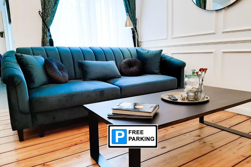 a blue couch in a living room with a coffee table at Wilhelmstadt Apartment 60m - PARKING in Toruń