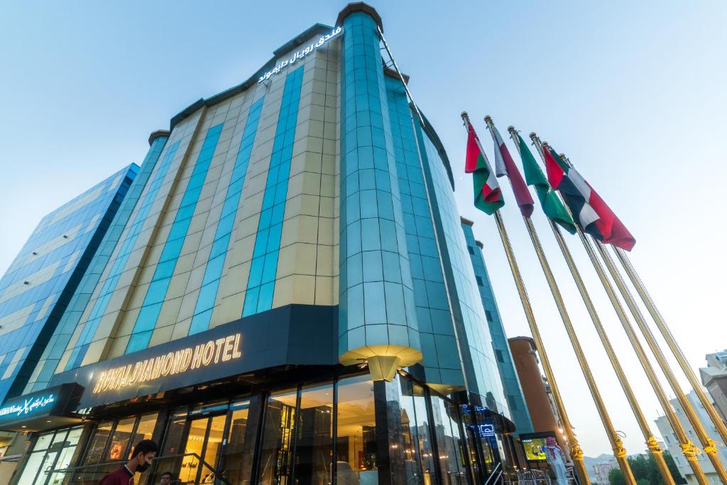 un grand bâtiment avec des drapeaux devant lui dans l'établissement فندق رويال دايموند الطائف, à Taif