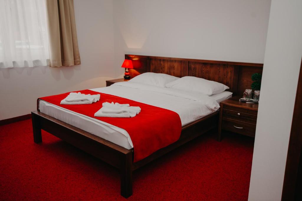 a bedroom with a bed with two towels on it at Motel Vila Bijela in Konjic