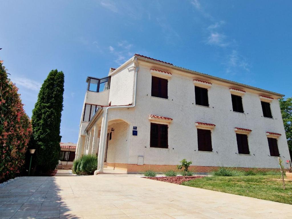 um edifício branco com janelas do lado em Apartments Regi Medulin em Medulin