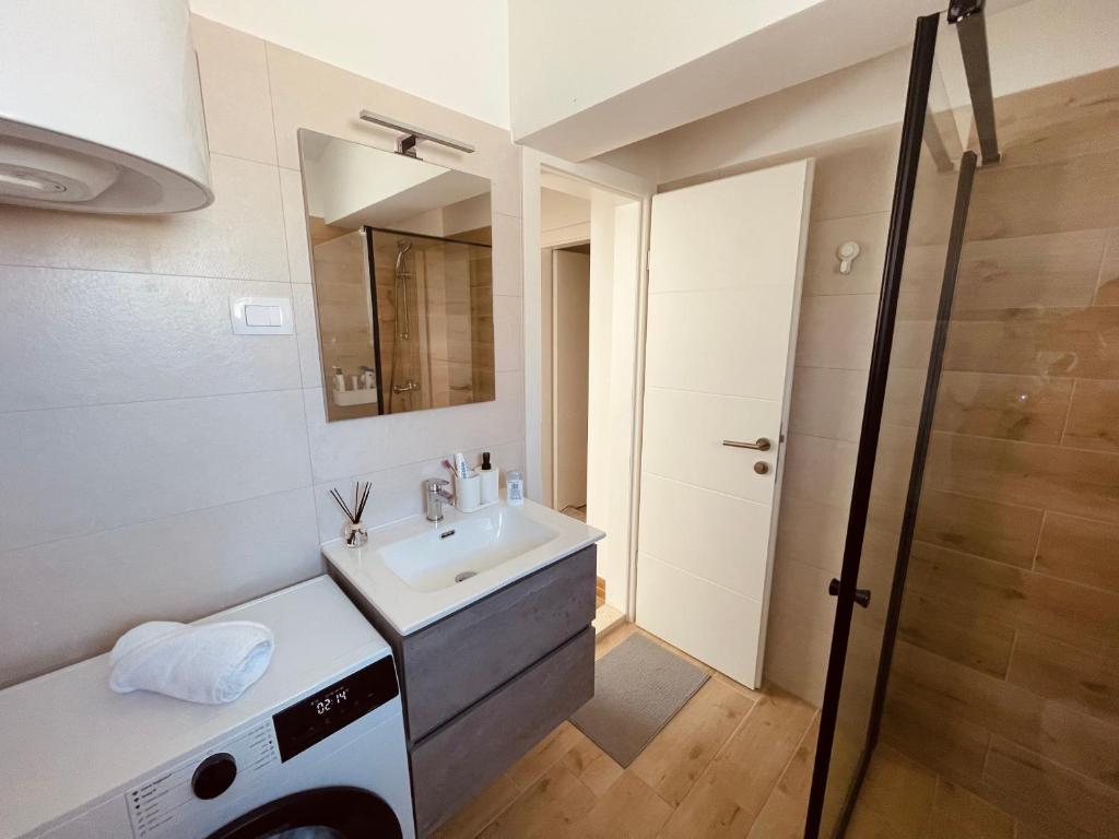 ein Bad mit einem Waschbecken und einem Spiegel in der Unterkunft White Truffle Pula in Marčana