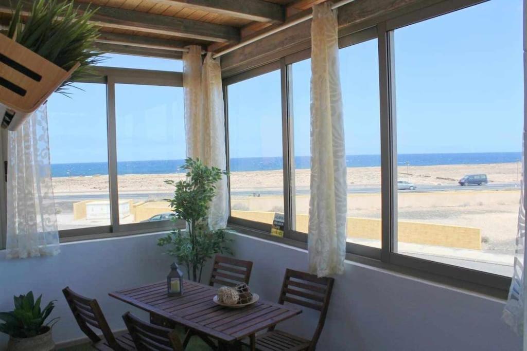 ein Esszimmer mit einem Tisch und Strandblick in der Unterkunft Casa Camille Vista al Mar in Costa de Antigua