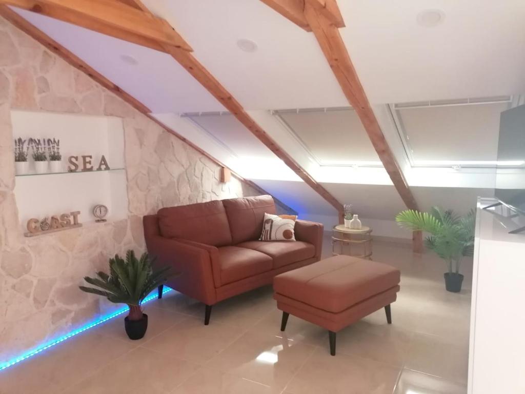 a living room with a couch and a stool at Sky apartment, Island Rab in Rab