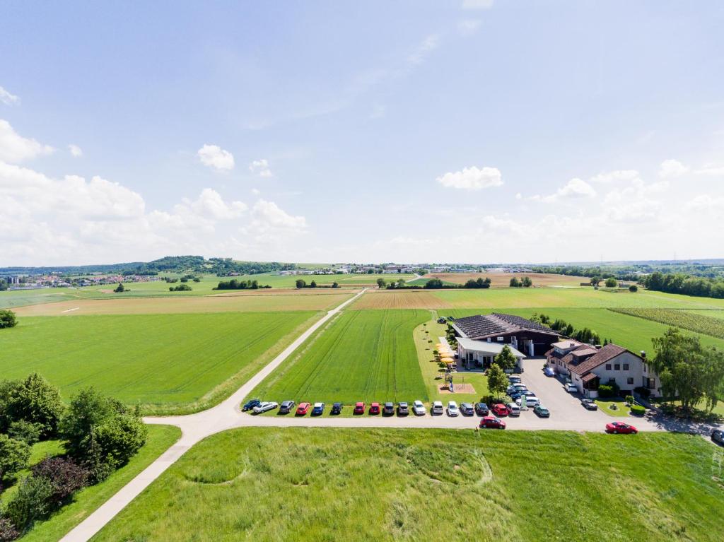 une vue aérienne sur une ferme avec un parking dans l'établissement Café & Wein Gästehaus Kurz, à Heilbronn
