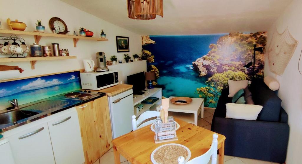 una cucina con lavandino e tavolo in una stanza di Studio de la Baie a Langueux