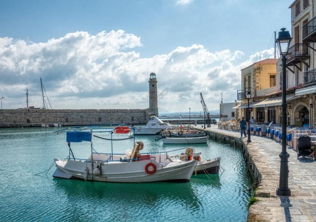 dos barcos están atracados en el agua en un puerto en Elysian Rose Residence en Rethymno Town