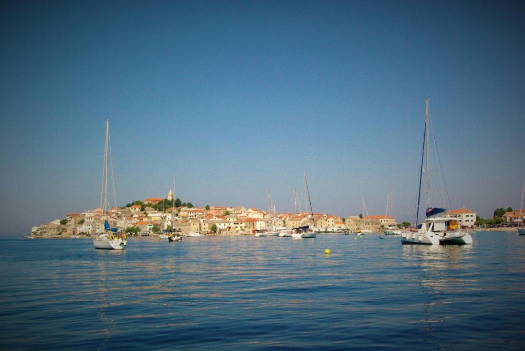a group of boats in the water with a town in the background at Rooms Plava Laguna in Primošten