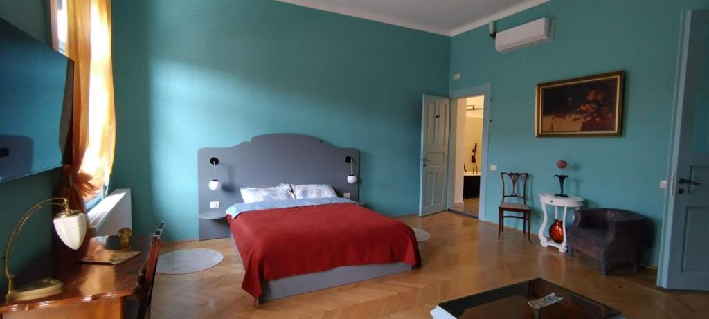 - une chambre avec des murs bleus et un lit avec une couverture rouge dans l'établissement Melina Studio, à Timişoara