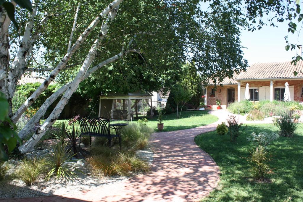 un jardin avec un banc et un kiosque dans l'établissement Les Milahinas, à Lescure-dʼAlbigeois