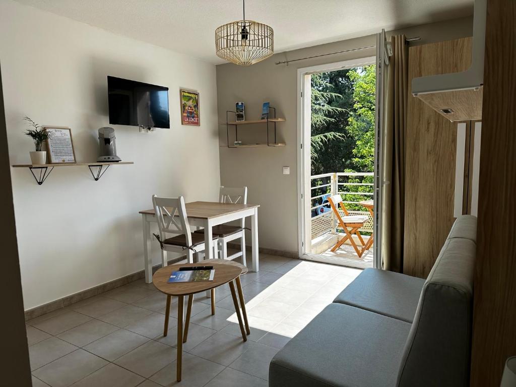 un salon avec un canapé et une table dans l'établissement Les locations Cinaureva « Le petit nid de l'Argentière », à La Londe-les-Maures